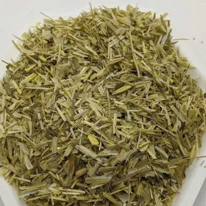 Pile of dried, shredded lemongrass stalks on a white surface.